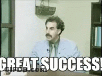 A Man With A Mustache Is Sitting At A Desk With The Words Great Success GIF