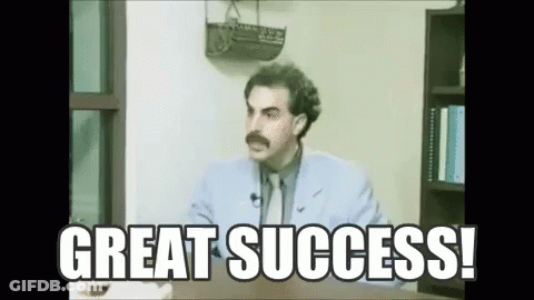 A Man With A Mustache Is Sitting At A Desk With The Words `` Great Success '' Written Above Him . GIF