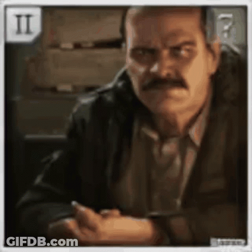 A Man With A Mustache Is Sitting At A Table With His Hands Folded GIF