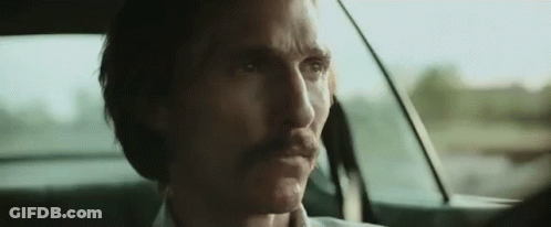 A Man With A Mustache Is Sitting In A Car . GIF