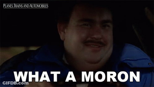 A Man With A Mustache Is Sitting In A Car With The Words What A Moron Below Him GIF