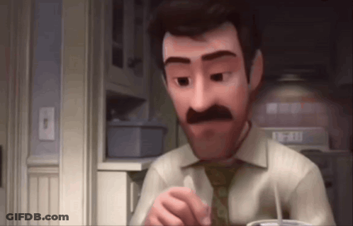 A Man With A Mustache Is Sitting In A Kitchen With A Cup Of Coffee In His Hand . GIF