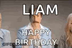 A Man With A Mustache Is Sitting In Front Of A Group Of People . GIF