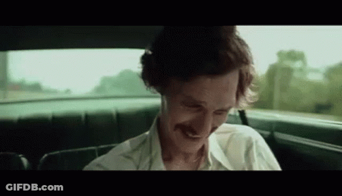 A Man With A Mustache Is Sitting In The Back Seat Of A Car Smiling . GIF