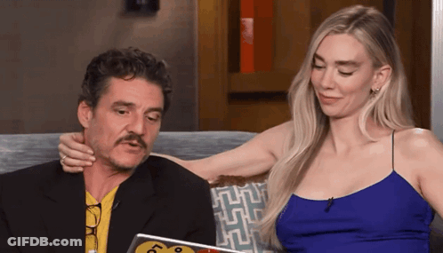 A Man With A Mustache Is Sitting Next To A Woman In A Blue Top GIF