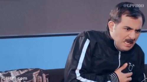 A Man With A Mustache Is Sitting On A Couch And Making A Funny Face GIF