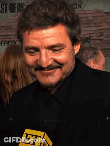 A Man With A Mustache Is Smiling And Holding A Microphone That Says Et On It GIF