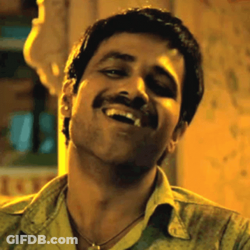 A Man With A Mustache Is Smiling And Making A Face . GIF