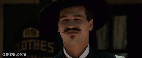 A Man With A Mustache Is Smiling In Front Of The Words Very Cosmopolitan GIF