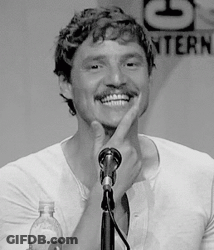 A Man With A Mustache Is Smiling While Talking Into A Microphone GIF