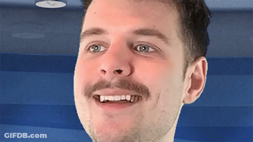 A Man With A Mustache Is Smiling With His Teeth Visible GIF