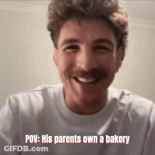 A Man With A Mustache Is Smiling With The Caption " POV : His Parents Own A Bakery " Above Him GIF