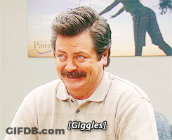 A Man With A Mustache Is Smiling With The Word Giggles On His Shirt GIF
