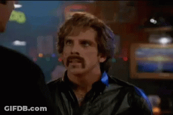 A Man With A Mustache Is Smoking A Cigarette And Talking To Another Man In A Bar . GIF