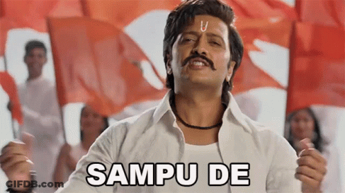 A Man With A Mustache Is Standing In Front Of A Crowd Holding Flags And Saying Sampu De GIF