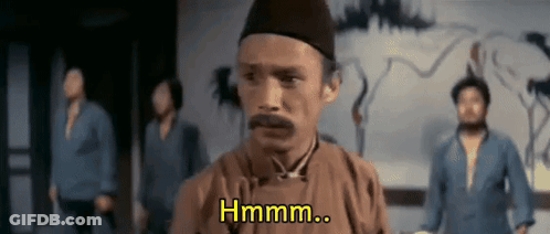 A Man With A Mustache Is Standing In Front Of A Group Of Men And Says Hmm .. GIF