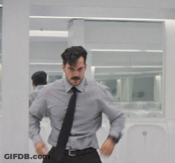 A Man With A Mustache Is Standing In Front Of A Mirror GIF
