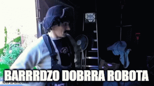 A Man With A Mustache Is Standing In Front Of A Sign That Says Barrrdz0 Dorra Robota GIF