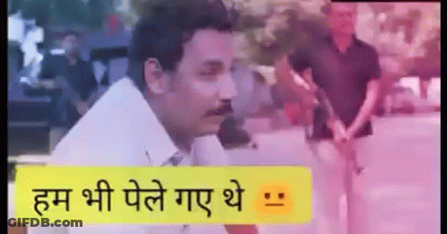A Man With A Mustache Is Standing In Front Of A Sign That Says `` हम भी पेले गए थे '' . GIF