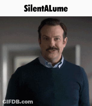 A Man With A Mustache Is Standing In Front Of A Silenta Lume Sign GIF
