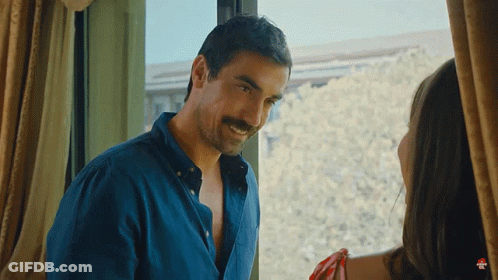 A Man With A Mustache Is Standing In Front Of A Window With A Woman GIF