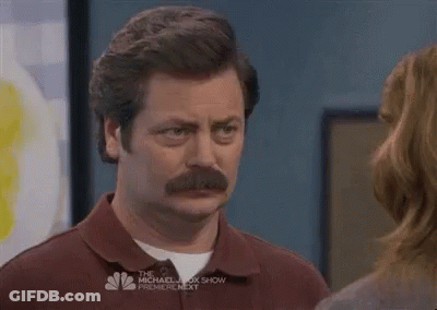 A Man With A Mustache Is Standing Next To A Woman And Looking At Her . GIF