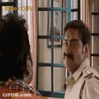A Man With A Mustache Is Standing Next To Another Man In A Room . GIF
