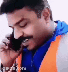 A Man With A Mustache Is Talking On A Cell Phone And Smiling . GIF