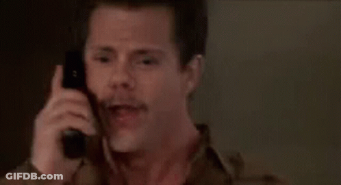 A Man With A Mustache Is Talking On A Cell Phone . GIF