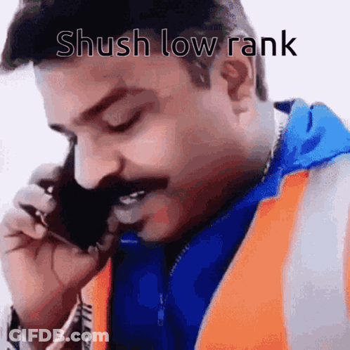 A Man With A Mustache Is Talking On A Cell Phone With The Caption Shush Low Rank . GIF