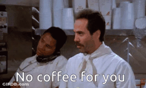A Man With A Mustache Is Talking On A Phone While Another Man Says No Coffee For You GIF