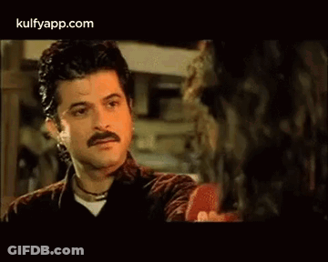 A Man With A Mustache Is Talking To A Woman . GIF