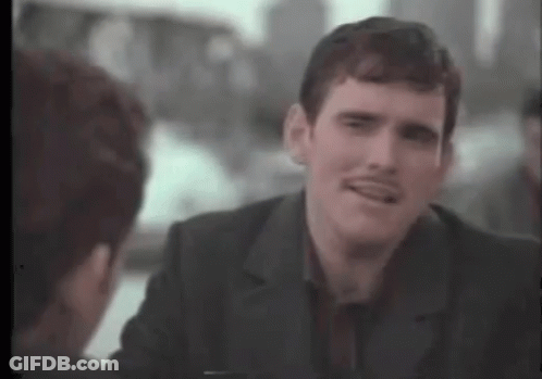 A Man With A Mustache Is Talking To Another Man In A Suit . GIF