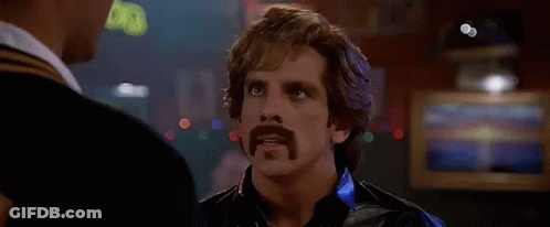 A Man With A Mustache Is Talking To Another Man In Front Of A Sign That Says " Touche " . GIF
