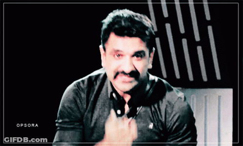 A Man With A Mustache Is Wearing A Black Polo Shirt With A White Horse On It GIF