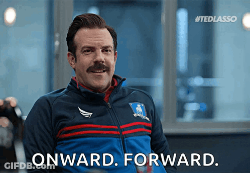 A Man With A Mustache Is Wearing A Blue Jacket That Says Onward Forward GIF