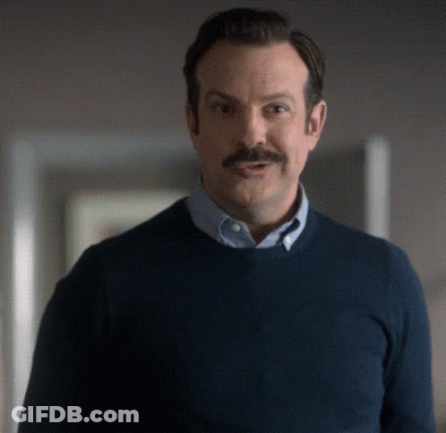 A Man With A Mustache Is Wearing A Blue Shirt And A Blue Sweater GIF