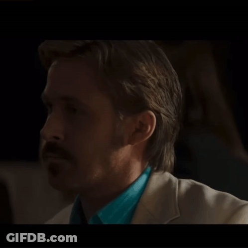 A Man With A Mustache Is Wearing A Blue Shirt And A White Suit GIF