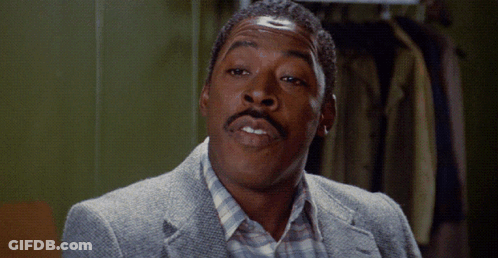A Man With A Mustache Is Wearing A Grey Jacket And A Plaid Shirt GIF