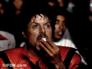 A Man With A Mustache Is Wearing A Michael Jackson Costume While Sitting In Front Of A Crowd . GIF