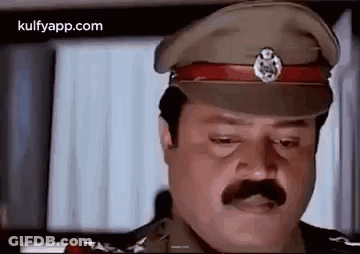 A Man With A Mustache Is Wearing A Military Hat And Looking Down . GIF
