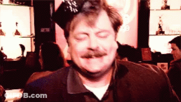 A Man With A Mustache Is Wearing A Party Hat And Making A Funny Face GIF