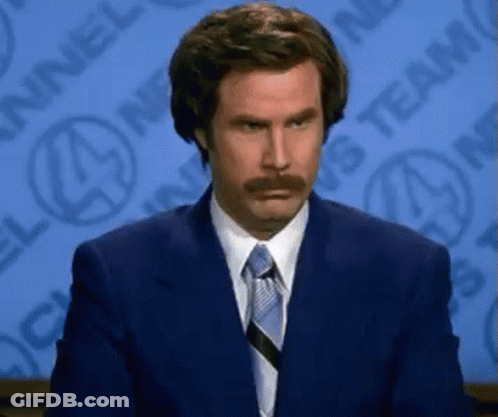 A Man With A Mustache Is Wearing A Suit And Tie GIF
