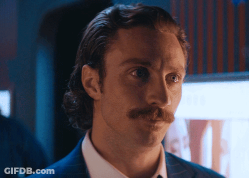A Man With A Mustache Is Wearing A Suit And White Shirt GIF