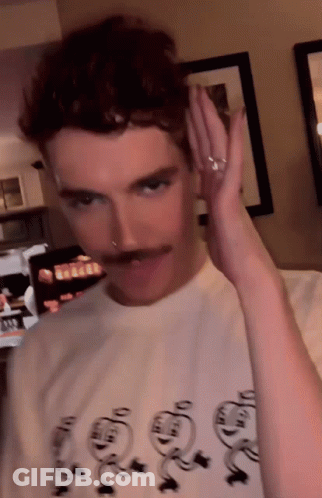 A Man With A Mustache Is Wearing A T-Shirt That Says ' Snoopy ' On The Front GIF