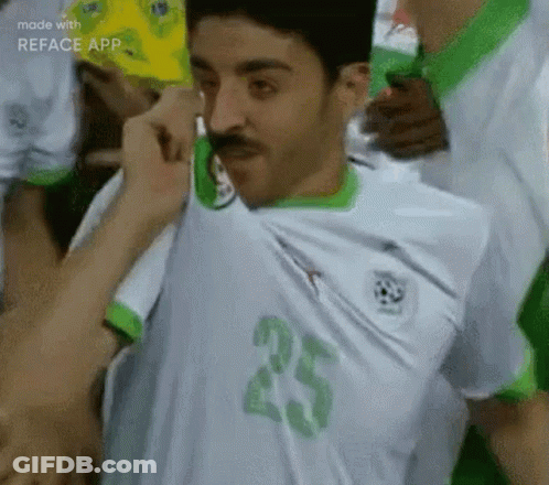 A Man With A Mustache Is Wearing A White And Green Soccer Jersey With The Number 25 On The Front . GIF