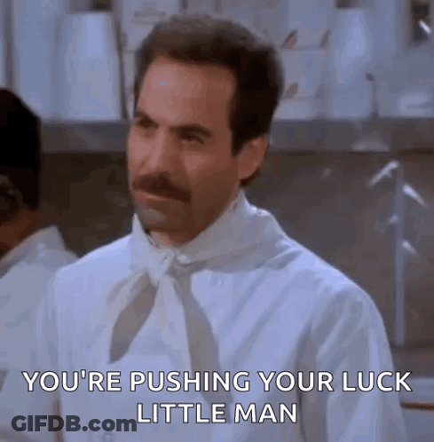 A Man With A Mustache Is Wearing A White Shirt And Tie And Is Pushing His Luck Little Man . GIF