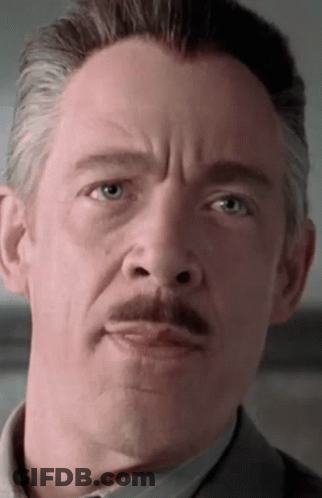 A Man With A Mustache Looks At The Camera GIF