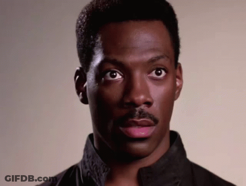 A Man With A Mustache Looks At The Camera With A Serious Look On His Face GIF