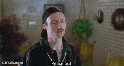 A Man With A Mustache Says Peace Out In A Room GIF